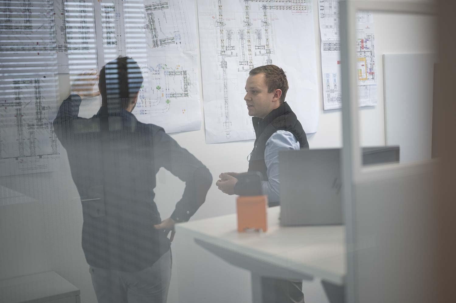 Teammeeting an einem Board mit Skizzen und Notizen